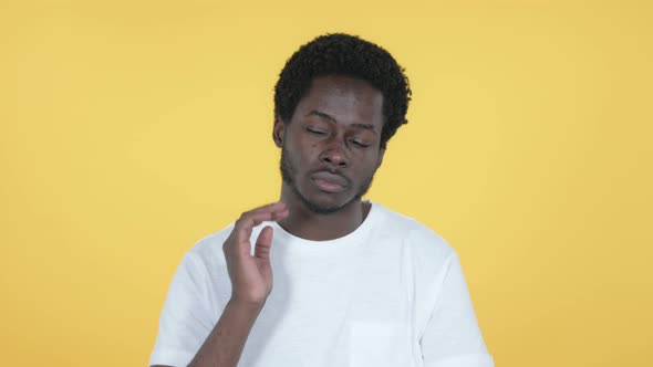 African Man with Neck Pain, Yellow Background