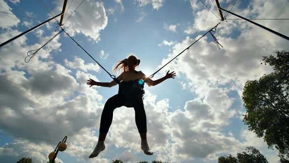 Teenage Girl Silhouette Jumping on the Trampoline Bungee Jumping