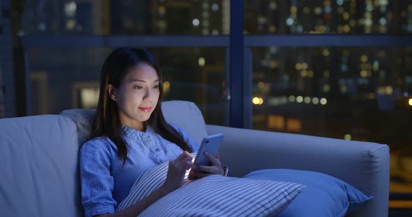 Woman watch on mobile phone at night