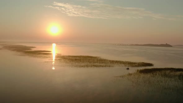 Aerial Drone View of Fisherman on the Boat on the Sunrise, Morning Fishing, Swimming on a Calm Lake