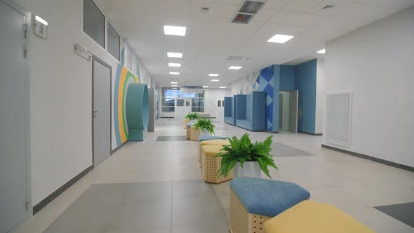 Soft Poufs and Houseplants in Empty Corridor of Kindergarten