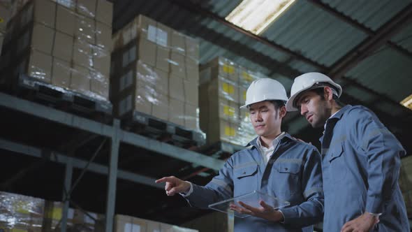 engineer staff male warehouse worker in hard hat working. walking through logistics center warehouse