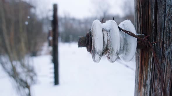 Closeup View of Snowcovered Electric Fence with Barbed Wires in Auschwitz Birkenau