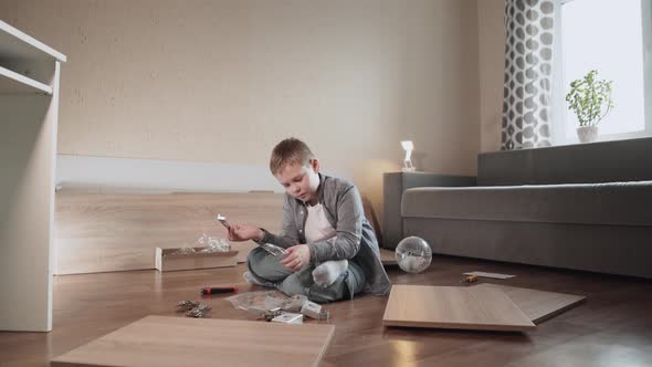 Boy Sits on Floor Among Wooden Panels