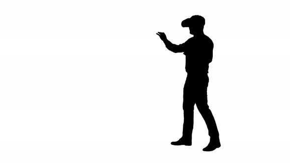 Silhouette Businessman in Virtual Reality Headset Walking in Virtual World.