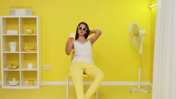 Pretty Woman Is Sitting In Yellow Office and Making Selfie