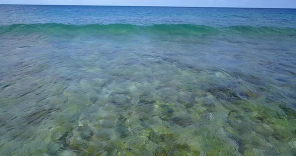 Daytime above travel shot of a sunshine white sandy paradise beach and turquoise sea background in c