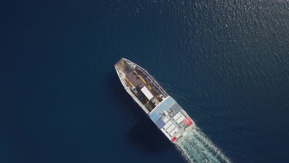 Aerial view above ferry boat with cars driving in the mediterranean sea, Greece.