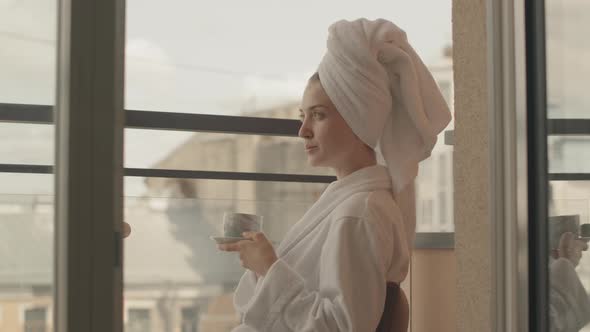 Portrait of Young Woman in Bathrobe Enjoying Morning Coffee