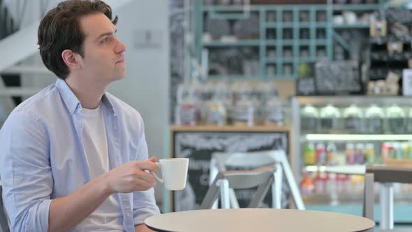 Young Man Drinking Coffee in Cafe