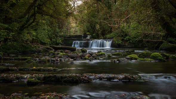 Time lapse of forest waterfall in rural landscape during autumn in Ireland. alt