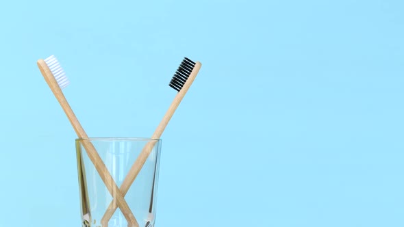 Two Bamboo Toothbrushes Rotating in Glass