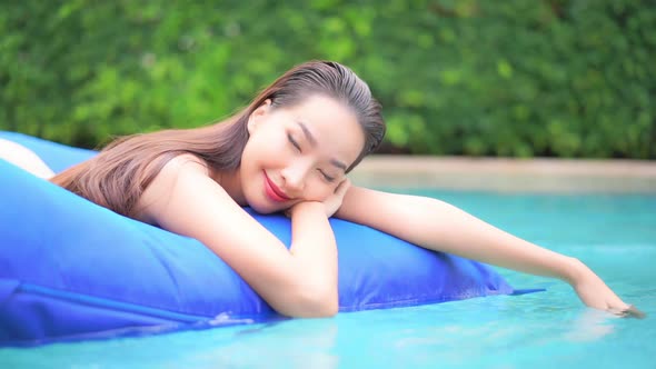 Young asian woman enjoy around outdoor swimming pool for leisure