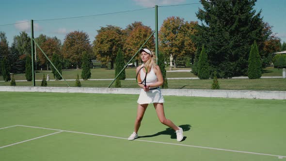 Professional Female Tennis Player Hits the Ball with a Racket Practice Game on the Tennis Court Hits