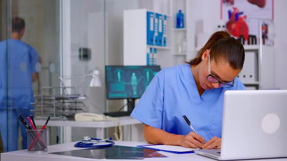 Exhausted Therapist Working on Laptop and Taking Off the Glasses