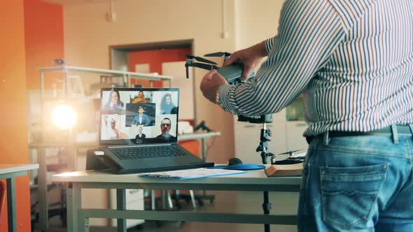 Male Tutor Is Showing a Drone During a Multiuser Online Class