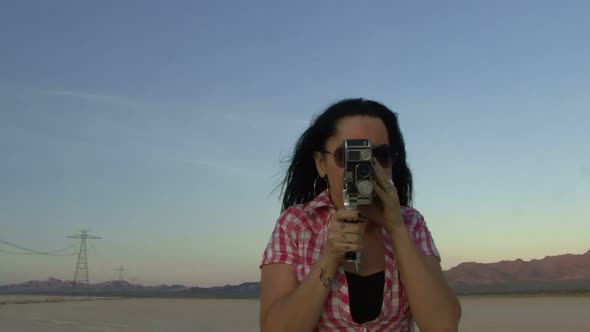 Female in desert using a cine camera