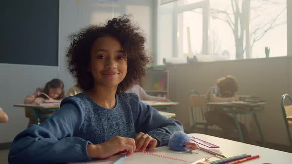 African Girl Sitting at Desk in Classroom