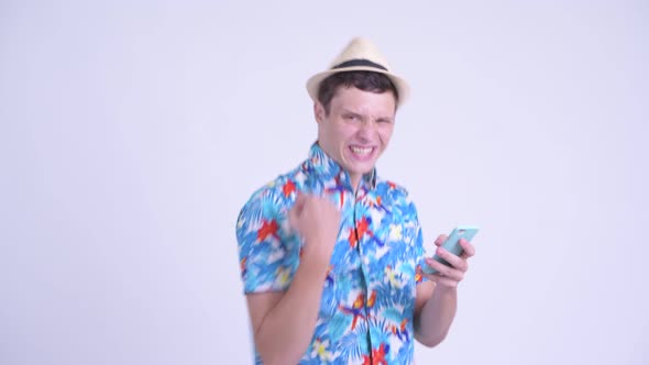 Happy Young Handsome Tourist Man Using Phone and Getting Good News