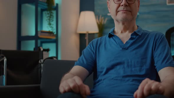 Portrait of Retired Adult with Chronic Disability Sitting on Sofa