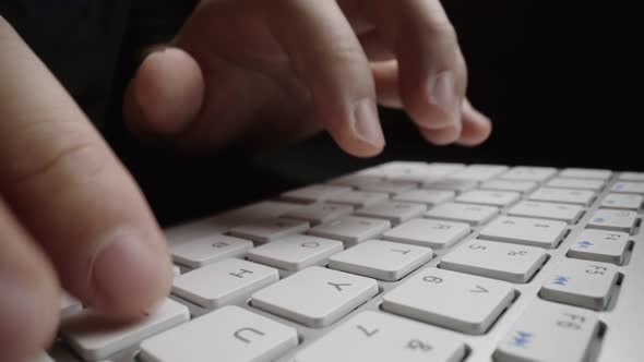 Close-up typing on keyboard with man fingers. Macro soft focus dolly shot.