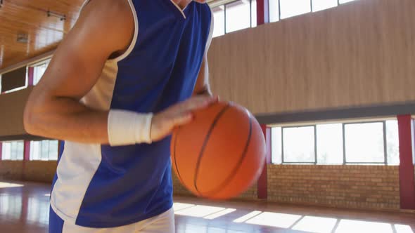 Caucasian male basketball player practicing dribbling and shooting with ball