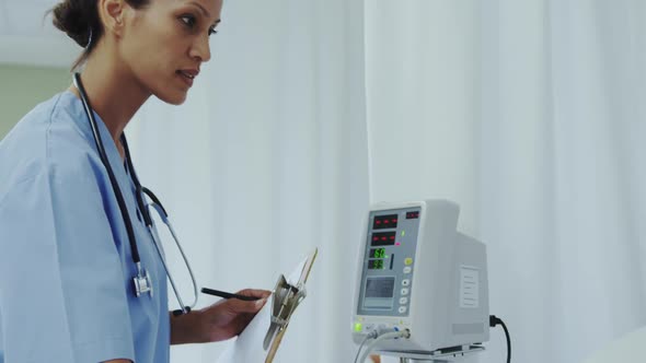 Side view of African american female doctor talking with female patient in ward at hospital 