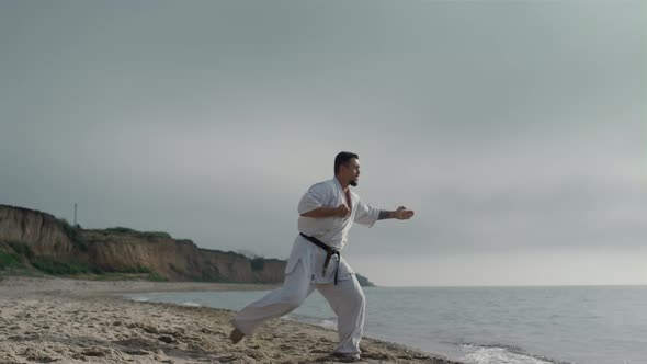 Karate Athlete Practicing Kicks on Sunny Beach