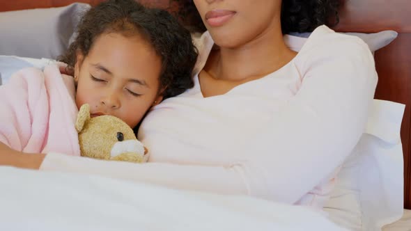 Front view of black mother and daughter sleeping in bedroom at home 4k