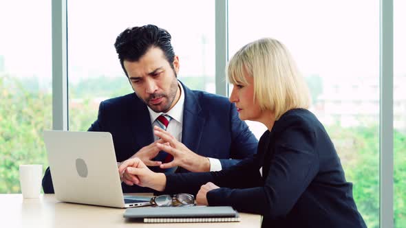 Two Business People Talk Project Strategy at Office