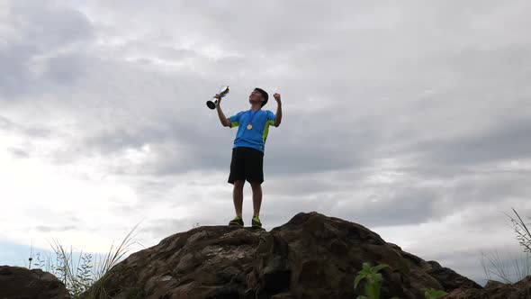 Man Rejoicing With Champion Cup On The Top