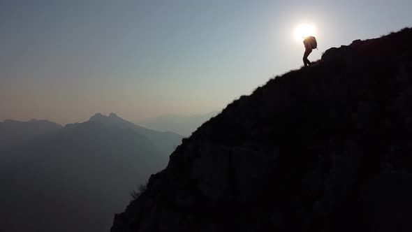 Hiker walking on mountain ridge, European Alps, Lecco, Italy