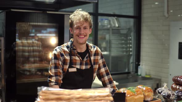 Portrait of the Handsome Man Baker in Plaid Shirt and Apron Smiling to the Camera and Posing in the