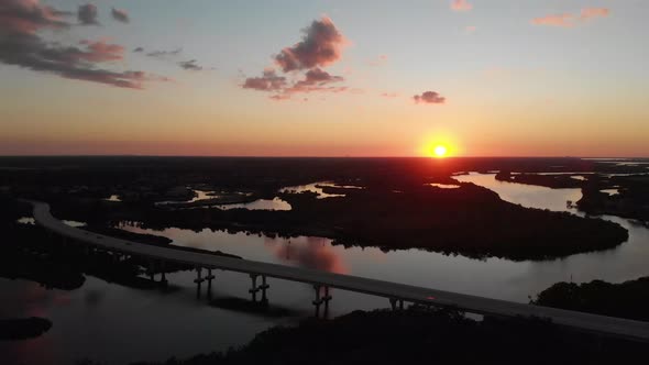 Aerial view falling back from a bridge, showing a beautiful sunset over the beautiful Manatee River