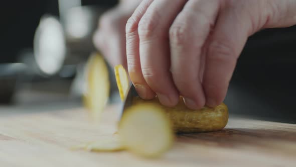 Chef Hands Slicing Dill Pickle