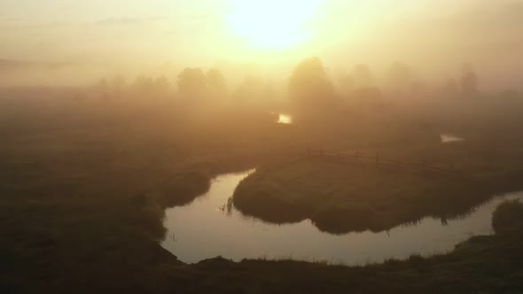 Atmospheric Aerial Flyover Amazing Foggy Valley Trees and River Covered with Thick Mist on Epic Warm