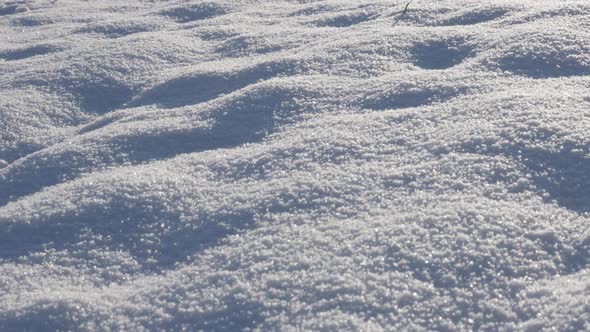 Close-up of snow white crystals  sparkling under sun slow tilt 4K 2160p 30fps UltraHD   footage - Sh