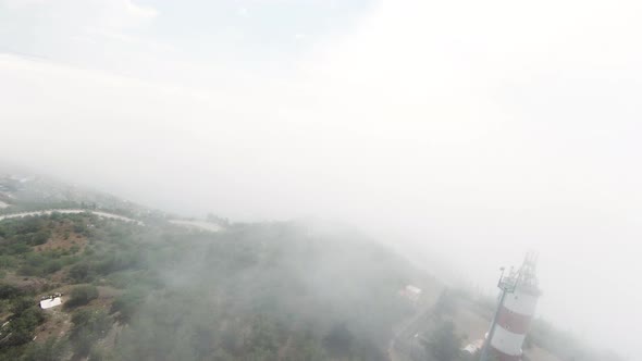 Aerial View of Hilly Green Region with Heavy Fog Above