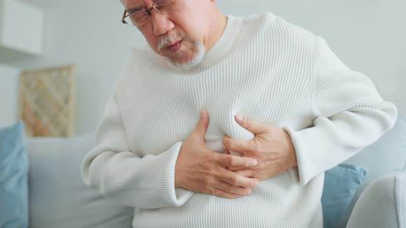 Asian senior older man having chest pain feel suffer from heart attack.