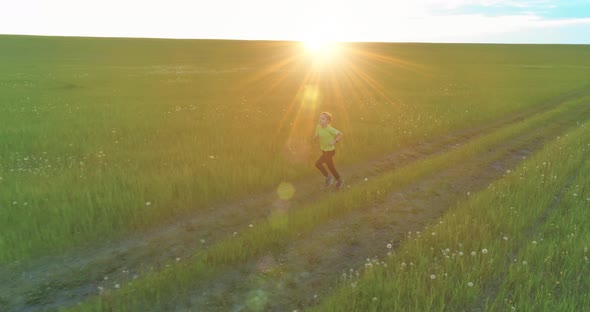 Sporty Child Runs Through a Green Wheat Field. Evening Sport Training Exercises at Rural Meadow. A