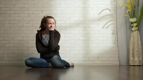 Depressed Woman Is Crying While Sitting on The Floor 