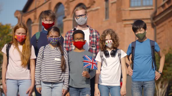 Portrait of Young Male Teacher and Multiethnic Pupils Outdoors with Union Jack Flag