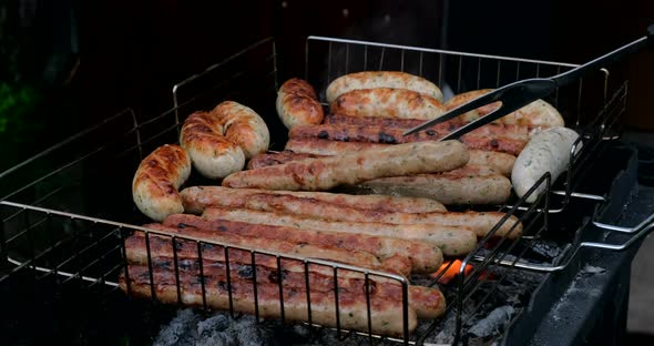 Sausages roasting on barbecue grill, outdoors