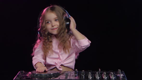 Little Girl in Headphones Plays for Dj Console. Black Background