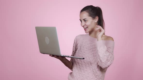 Half Side View of a Cheerful Young Caucasian Woman Talking By Video Call