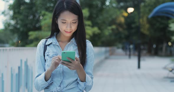 Woman looking at mobile phone in the evening