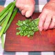 Slicing green onions with a knife on a cutting board - VideoHive Item for Sale