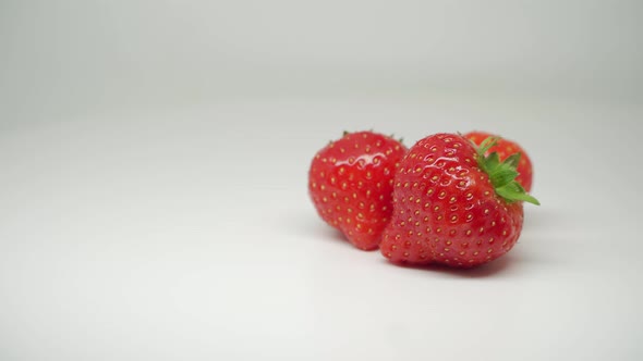 Three Sweet Red Strawberries Fruits At the Top of The Turn-Table - Close Up Shot