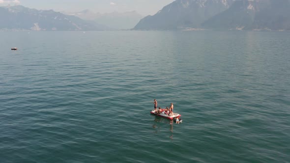 Aerial of kids on a paddle boat in a large beautiful lake