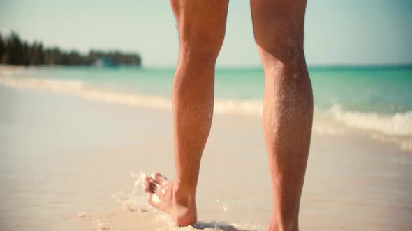 Man In Shorts Resting On Ocean Idyllic Exotic Beach. Man Legs Walking On Tropical Beach.